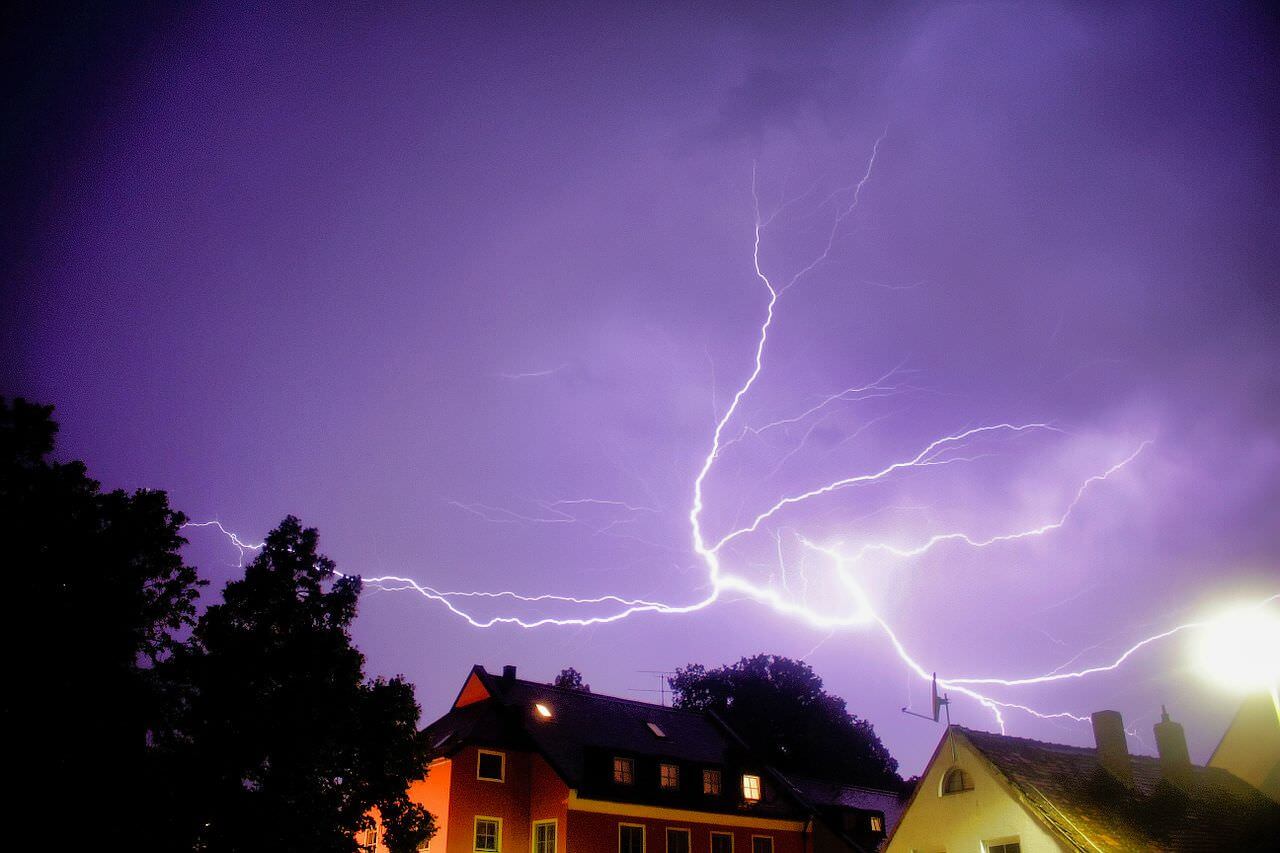 Gewitter mit Blitz über Häusern